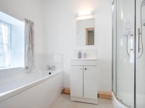 伯克利本高翼楼别墅的白色的浴室设有浴缸、水槽和淋浴。