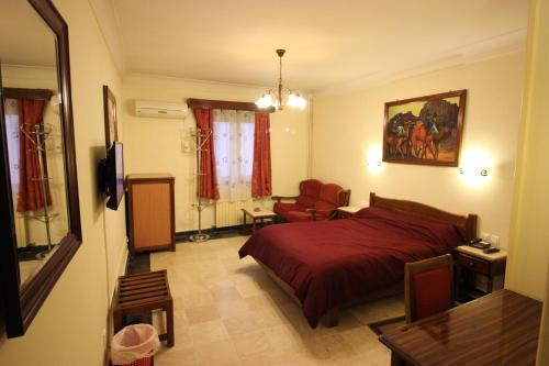 阿尔及尔Hotel Hydra的一间卧室配有红色的床和椅子