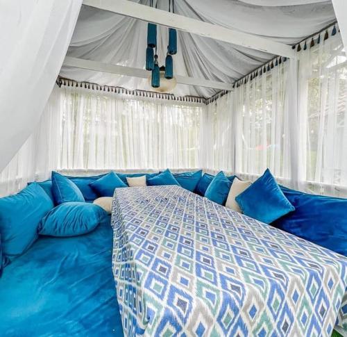 阿拉木图Panorama Hills的一间帐篷内带蓝色床的卧室