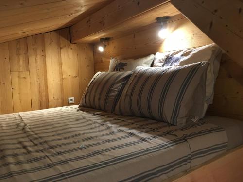 热拉梅LES BALCONS DU PHENY LE REFUGE的木墙和天花板的客房内的一张床位