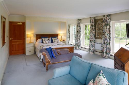 剑桥教区农场酒店的一间卧室配有一张床和一张沙发