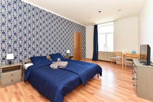 文茨皮尔斯Telegrafs的一间卧室配有蓝色的床和电视