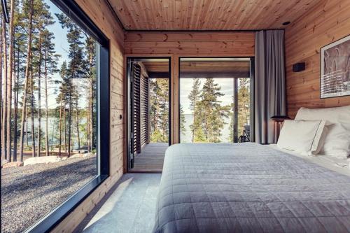 萨洛Saunamäki Resort - Lux Villa的卧室设有大窗户和一张床