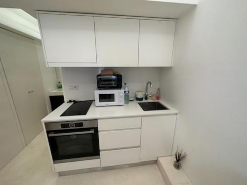 蒙特卡罗Studio port hercule Monaco的小厨房配有白色橱柜和微波炉
