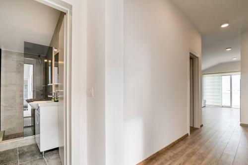 比耶拉Bright Apartment的厨房拥有白色的墙壁和木地板