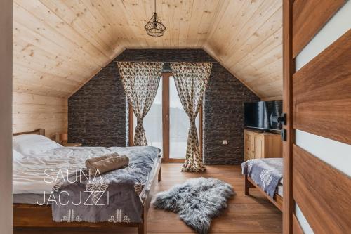 新塔尔格Gorczański Resort Domek w Górach Sauna Jacuzzi的一间卧室设有一张床和砖墙