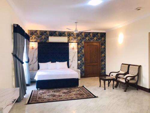 伊斯兰堡Royal Palace Boutique Hotel的一间卧室配有一张特大号床和一把椅子