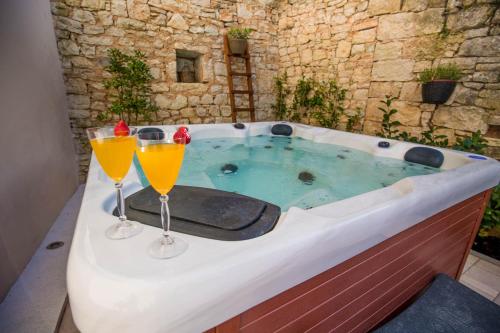 斯维特温斯纳特CASA MARIO-charming stone house with jacuzzi的浴缸上放两杯橙汁