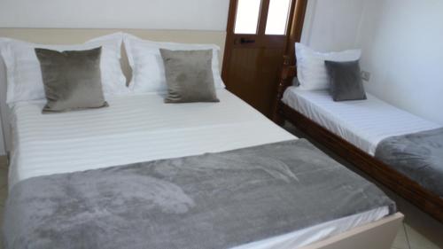 地拉那Deni's Family Apartment in New BLVD的配有2张床的带白色床单和枕头的客房