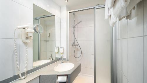 吕德斯海姆环形中央酒店 - 高级的白色的浴室设有水槽和淋浴。