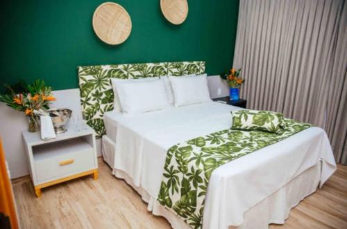 皮廷布Resort Asenza Bangalô Barão 503的卧室配有白色的床和绿色的墙壁