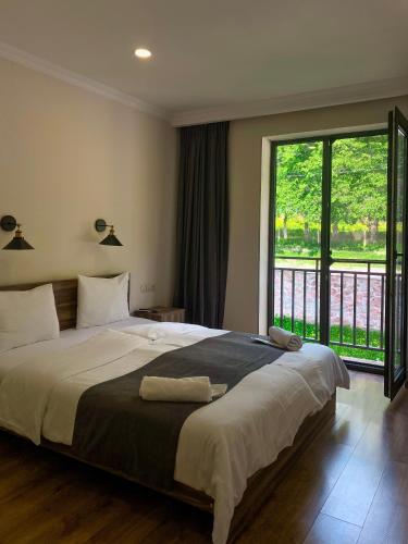 卡兹贝吉Hotel Gold Kazbegi的一间卧室设有一张大床和一个大窗户