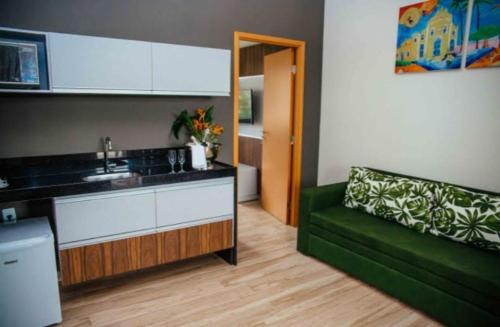 皮廷布Resort Asenza Bangalô Barão 503的一间带绿色沙发的客厅和一间厨房