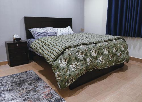 拉瓦尔品第QB Elegant Villa Bahria Town的一间卧室配有一张带毯子和床头柜的床
