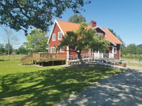 SollebrunnÄppelgården的大型红色房屋设有大型木制甲板
