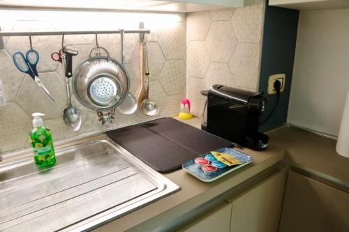 都灵A due passi dal Centro & Parcheggio Gratuito的厨房柜台设有水槽和微波炉