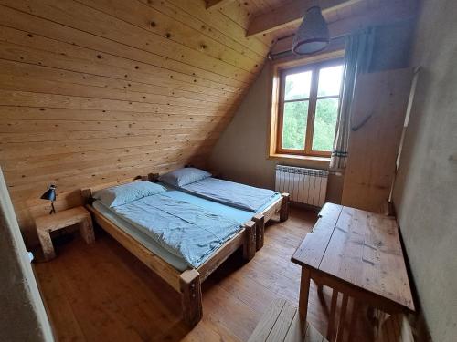 LipieLipie12a - pokoje的木制客房内的一间卧室,配有一张床
