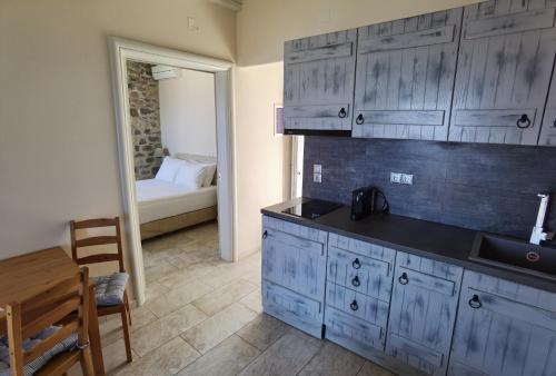 伊拉克利亚岛Villa Panorama的厨房配有蓝色橱柜、桌子和床。