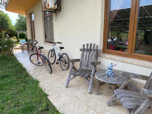 布尔加沃Guest House Golden Flake 4km from Bolata beach的房屋旁的长凳和两辆自行车