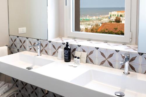 西尼加利亚水晶酒店的一间带两个盥洗盆和大镜子的浴室