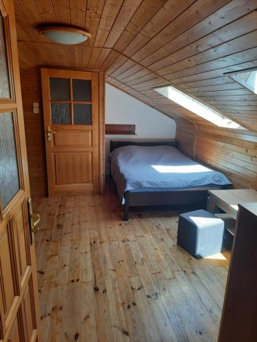 姆热日诺Pokoje Mrzeżyno的一间卧室设有一张床和木制天花板