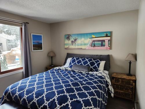 威斯康星戴尔加勒比海俱乐部度假酒店的卧室配有蓝色和白色的床和窗户。