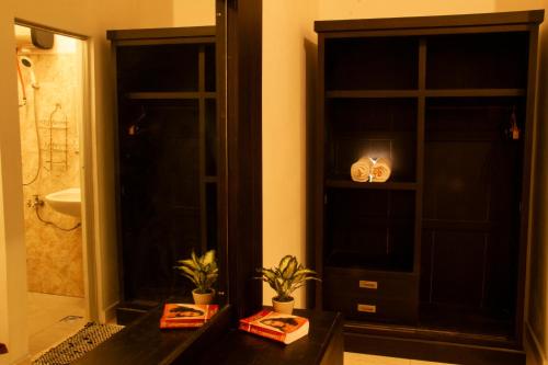乌鲁瓦图乌玛武吉酒店的浴室设有黑色的门和植物桌子
