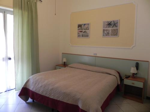 维亚雷焦翁蒂娜酒店的一间卧室设有一张床和一个窗口