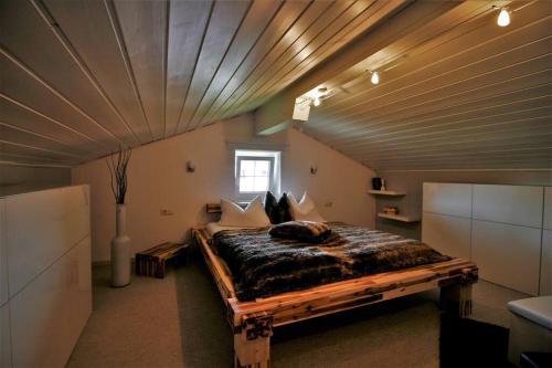 基姆湖畔布赖特布伦Ferienwohnung Heimatglück 2-3 Personen WLAN的一间卧室设有一张带木制天花板的大床