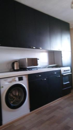 CorjovaДубоссары ,ул.Ломоносова 8 А的厨房配有洗衣机和黑色橱柜。