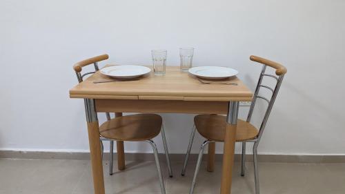 Beʼer OraThe Brill'S - הברילים的一张木桌,上面有两把椅子和两杯眼镜