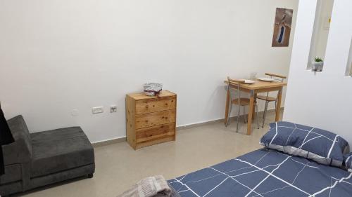 Beʼer OraThe Brill'S - הברילים的一间卧室配有一张床、一把椅子和一张桌子