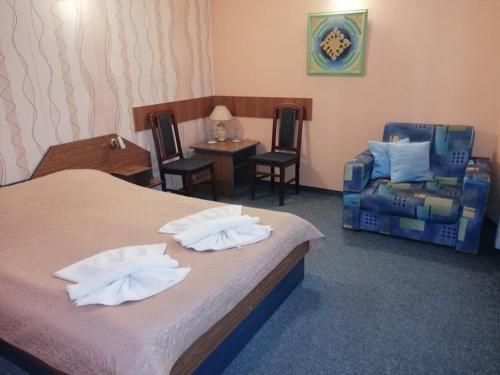 旧扎戈拉ХОТЕЛ ОМЕГА的配有床、椅子和桌子的酒店客房