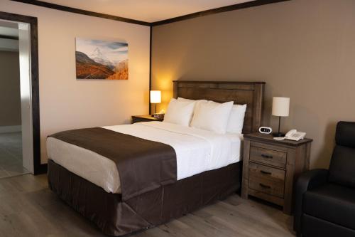 BeresfordMotel 7 Inn & Suites的酒店客房带一张大床和一把椅子