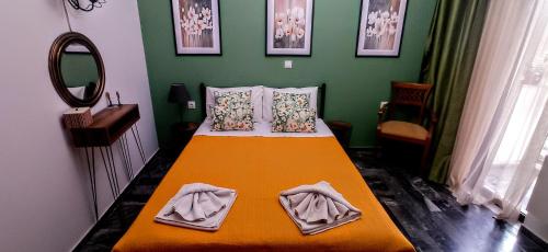 斯卡拉卡伦尼斯Nancy Rooms的一间卧室配有一张带橙色毯子和镜子的床