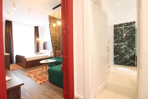 萨拉热窝Sarajevo History Apartments的一间带红色门的客厅和一间带沙发的房间