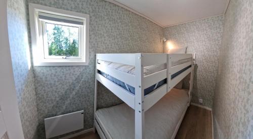 孙讷Nygård Cabins - brandnew holiday home with 3 bedrooms的一间卧室设有两张双层床和一扇窗户。