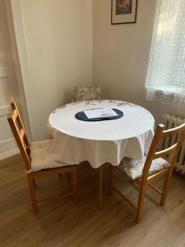 布拉格Apartmán Colette的餐桌、两把椅子和一张白色桌子