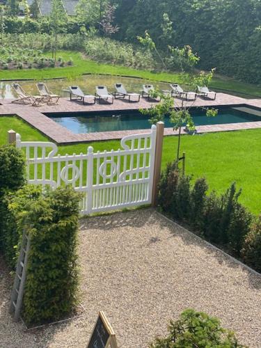 博尔赫隆Villa Copis的一个带椅子的白色围栏和一个院子内的游泳池
