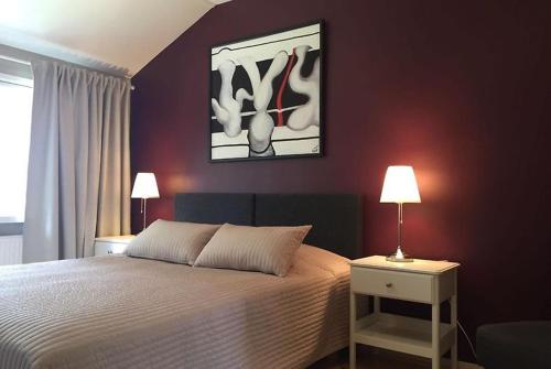 萨翁林纳Norppa Resort的卧室配有一张床,墙上挂有绘画作品