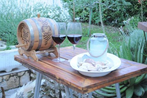 班约勒Little house Kućica的一张桌子,上面放着两杯葡萄酒和一个花瓶