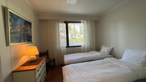 艾赫泰里Huoneisto karhujen kaupungissa - Tapanintien Lumo的酒店客房设有两张床和窗户。