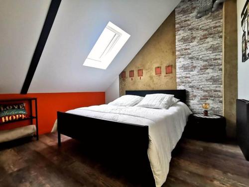 鲁昂Logement Industriel & Atypique的一间卧室设有一张大床和砖墙