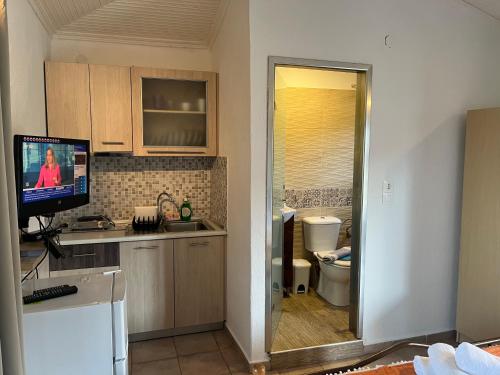 沃尔沃罗Apartment & Studios Haido的厨房设有台面上的电视和卫生间。