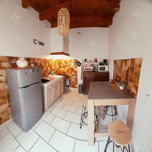 阿尔勒La maison de Toinette的厨房配有冰箱和桌椅