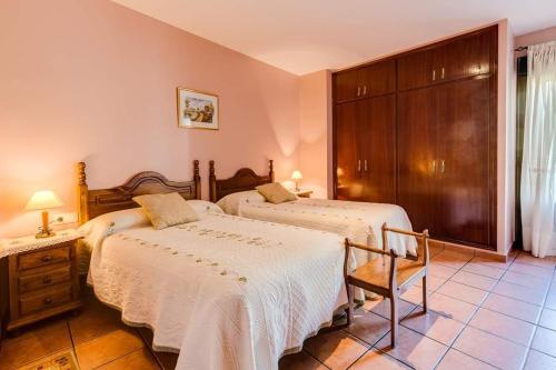 VillamielRestaurante & Casa Rural Boada的一间卧室配有两张床和椅子