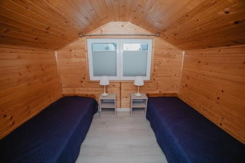 库兹尼卡DOMEK MIEDZY MORZAMI的木房内设有两张床的房间