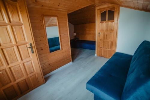 库兹尼卡DOMEK MIEDZY MORZAMI的客厅设有蓝色的沙发和门。