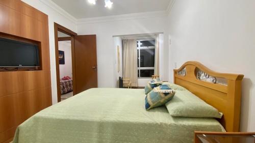 瓜拉派瑞Luxuoso a 250 Mts da Praia的一间卧室配有一张床,电视
