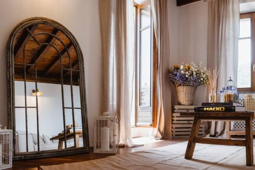 SomeraroHistorical Penthouse on Isola dei Pescatori的一间设有镜子和鲜花桌的房间